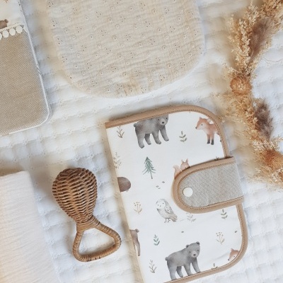 Estojo de bebé com estampas de animais e acessórios de bebé sobre tecido branco