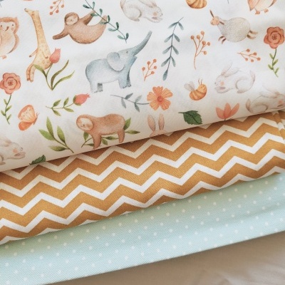 Tecidos com estampas de animais e padrões em tons pastel