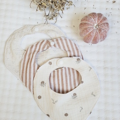 Babetes de bebé em tecido creme e castanho claro com flores e riscas, abóbora cor de rosa pequena e flores secas