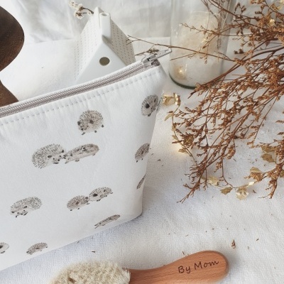 Bolsa branca com ouriços e escova de madeira com cerdas