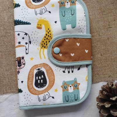 Capa de tecido infantil com estampado colorido de animais e texto ROA RR