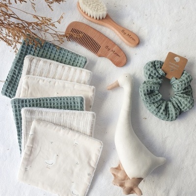 Conjunto de cuidados pessoais com escova, pente, panos, laço e brinquedo de ganso