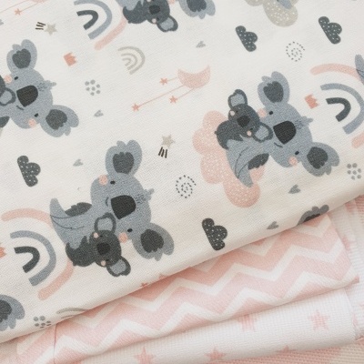 Tecidos com padrões de coalas, arcos-íris e estrelas em tons pastel