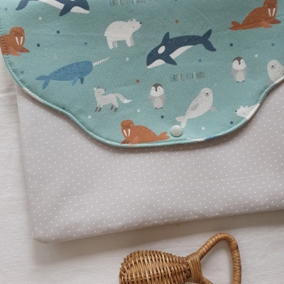 Mala azul com padrão de animais marinhos e chocalho de madeira