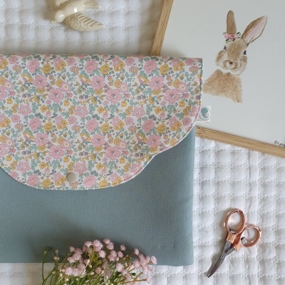 Estojo flores rosa e amarelas, tesoura cobre, flores, ilustração coelho moldura madeira sobre cobertor branco