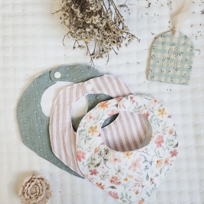 Três babetes de tecido para bebés com diferentes padrões e etiqueta Oh baby!