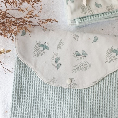 Bolsa têxtil azul claro com aba branca decorada com pássaros e folhas