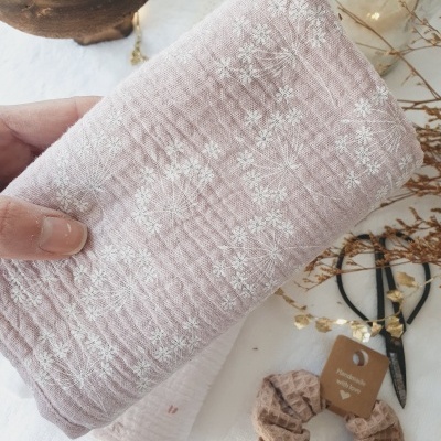 Toalha rosa claro com padrão branco de flores pequenas