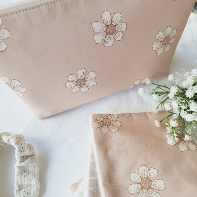 Estojo rosa claro com flores brancas estampadas sobre pano branco