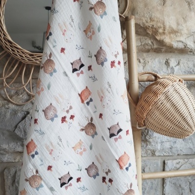 Tecido branco com padrão de animais de floresta pendurado em estrutura de bambu