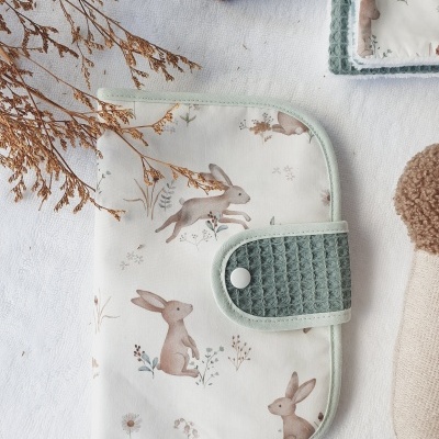 Carteira ou organizador de tecido com padrão de coelhinhos e flores, fecho verde salvia com botão