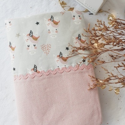 Toalha com padrão de unicórnios e tecido rosa com fita ondulada