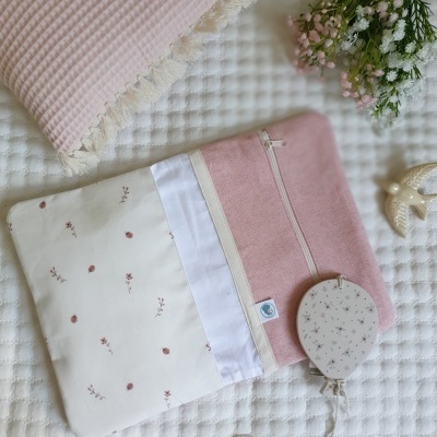 almofada rosa, nécessaire rosa e branca com padrão floral, balão decorativo com padrão floral, ramo de flores, colcha branca texturizada