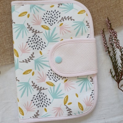 Estojo organizador em tecido branco com padrão floral e fecho rosa claro