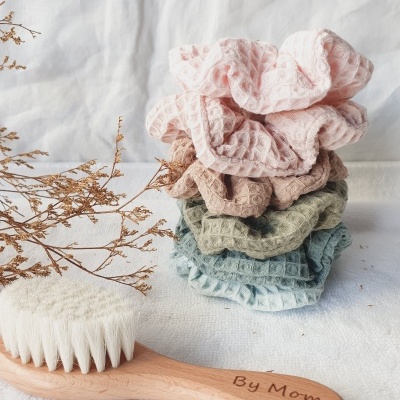 Scrunchies coloridos empilhados e escova de madeira com cerdas brancas