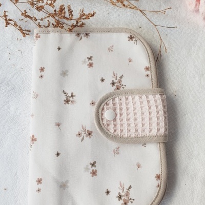 Estojo florido com fecho em tecido texturizado num fundo claro