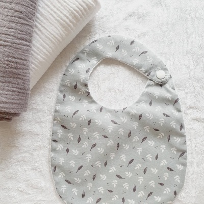 Babete para bebé cinza claro com padrão de folhas pequenas em branco e castanho