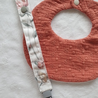 Babete bebé cor tijolo com textura floral e presa-chuchas floral