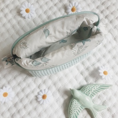 Necessaire verde água com padrão texturizado, interior com estampa de pássaros, e pássaro decorativo verde água em cerâmica