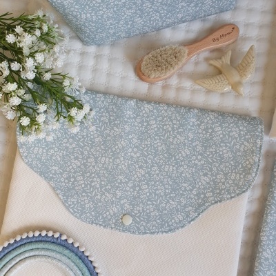 Bolsa branca com aba azul claro estampada, escova de madeira, figuras de anjos, flores e suporte de crochê