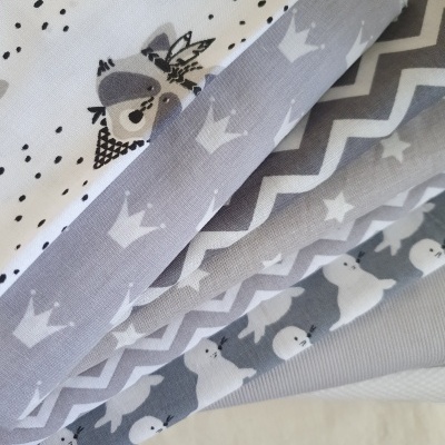 tecidos com estampas de ursos, coroas, zig-zags e pontos em cinza, branco e preto