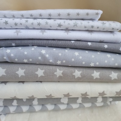 tecidos empilhados com padrão de estrelas em cinza, branco e bege