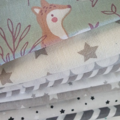 Tecido com padrões de estrelas, listras, raposa e pássaro