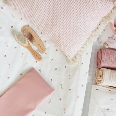Travesseiro rosa claro, escova e pente em madeira, tecidos rosa e bege com padrão floral