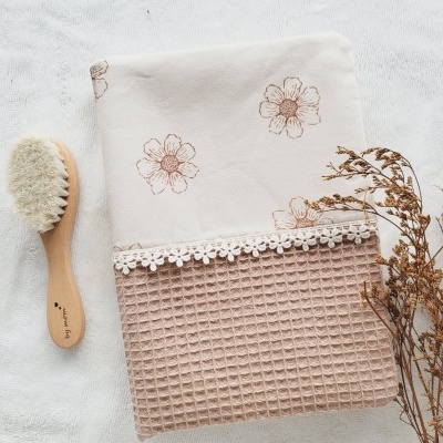 Toalha com flores castanhas e padrão waffle, escova de madeira, raminho seco