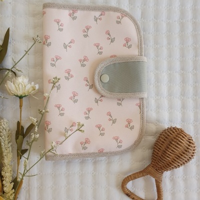 Carteira floral com fecho cinza e chocalho de ráfia ao lado