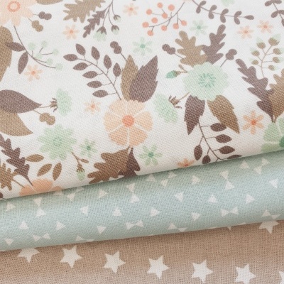 Três tecidos com padrões florais, triângulos e estrelas em tons pastel.