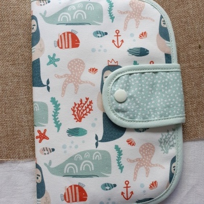 Estojo tecido padrão marítimo com golfinhos, polvo, peixes e âncoras, fecho botão branco.