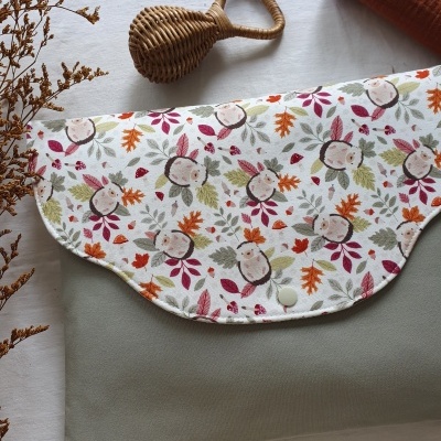 Bolsa ou muda fraldas com tampa estampada e corpo cinza com brinquedo de madeira ao lado