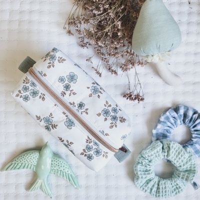 Estojo floral com brinquedos e scrunchies em tecido branco texturizado