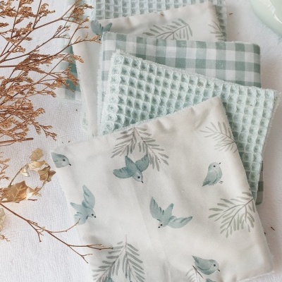 Panose de tecidos com padrões xadrez, waffle e estampa de pássaros em tons verdes e azuis