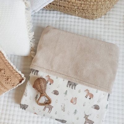 Manta de bebé com padrão de animais e chocalho de madeira