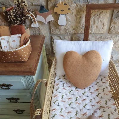 Berço de verga com almofada em forma de coração castanha e colchão com padrão de libélulas