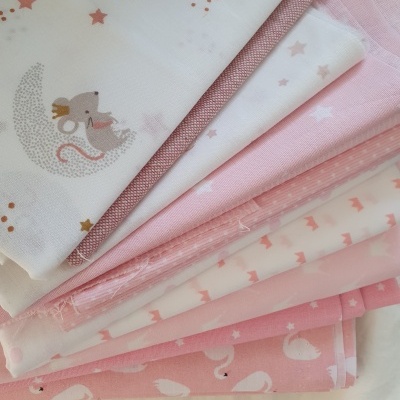 tecidos rosa e branco com padrões de ratinhos, estrelas e cisnes