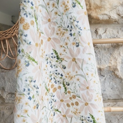 Tecido branco com padrão floral em tons pastel pendurado