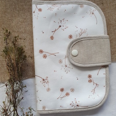 Carteira ou estojo bege claro com padrões de ramos secos castanhos e fecho de mola branco