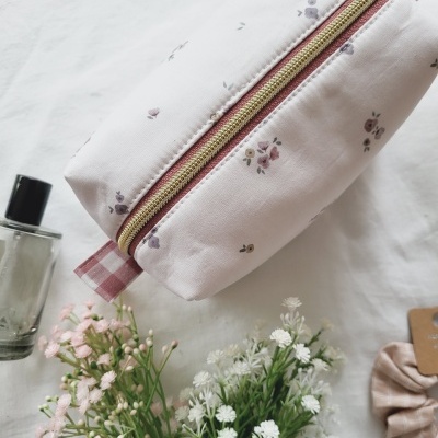 Necessaire rosa claro com padrão de flores e fecho dourado