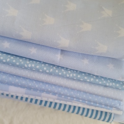 Pilha de tecidos azuis com diferentes padrões, como pássaros, bolinhas e riscas