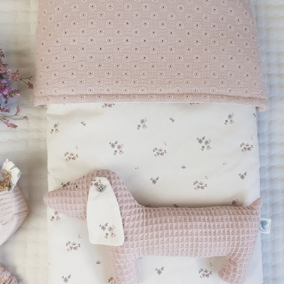 Cobertor rosa, manta branca com flores e brinquedo de cão de peluche rosa com textura waffle