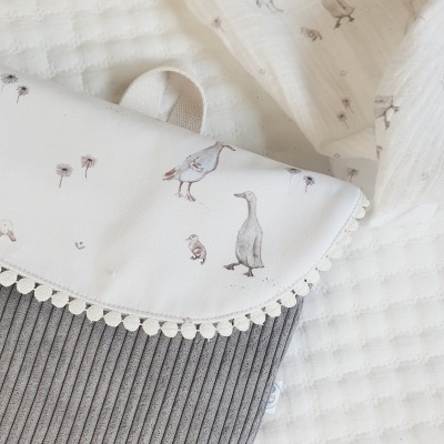 Mala cinzenta de veludo cotelê com aba branca estampada com aves e flores, borda de pompons brancos