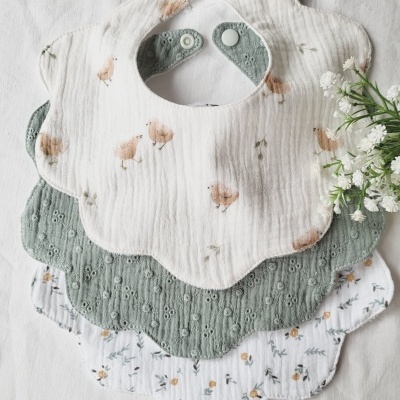 Conjunto de três babetes de tecido em forma de flor com diferentes padrões e fecho de pressão