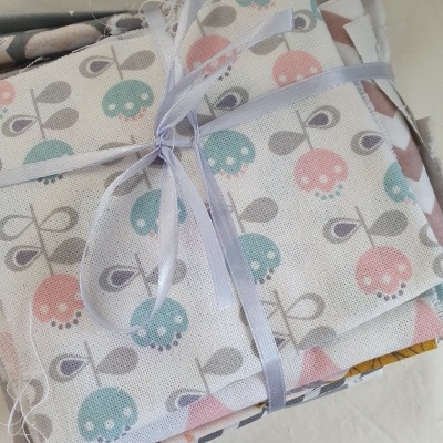 Tecido com padrão de flores coloridas empilhado e amarrado com fita azul clara