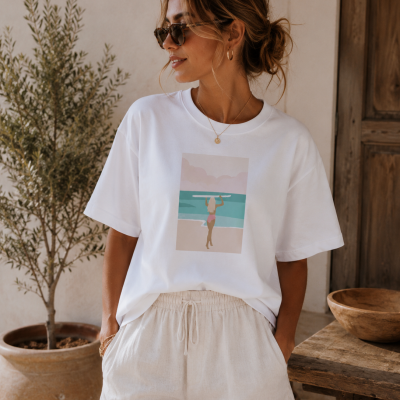 Mulher de t-shirt branca com estampa de surfista e calções bege