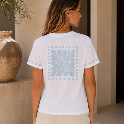 T-shirt branca com padrão floral azul claro nas costas e mangas, vista de trás.