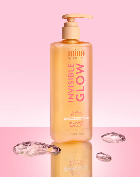 Invisible Glow Tan Gelly - Gel Bronzeador Gradual Hidratante Frasco amarelo com doseador de hidratante para bronzeado sobre fundo rosa e gelo transparente.