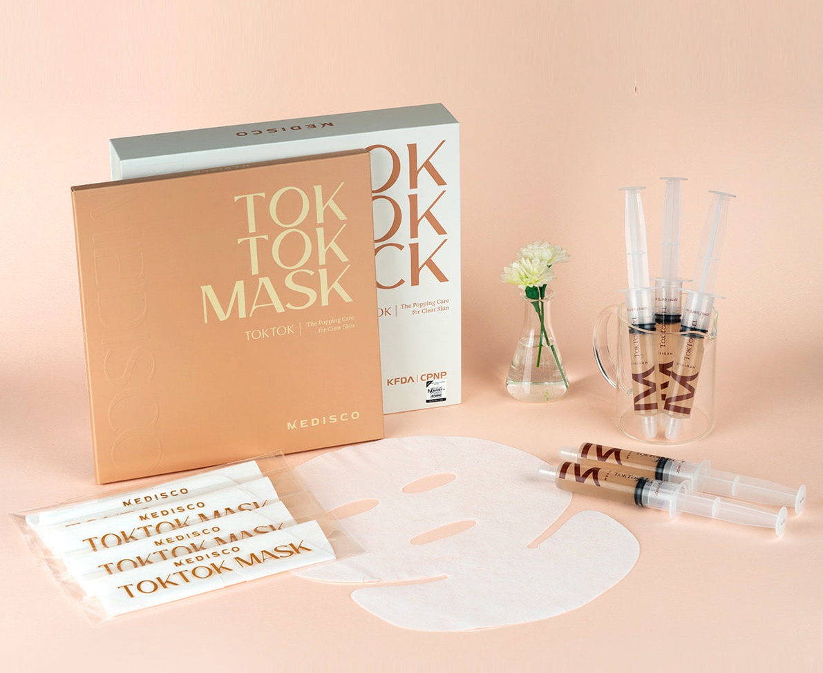 Kit Tok Tok Medisco Stayve Pacotes de TOKTOK MASK da MEDISCO com máscara facial branca e seringas em fundo pêssego
